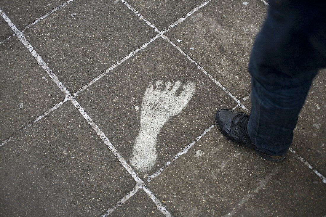 Adult, Adults, Anonymous, Big, Color, Colour, Concept, Concepts, Daytime, detail, details, exterior, Feet, Foot, Footprint, Footprints, Ground, Grounds, human, Large, Odd, One, One person, Original, Originality, outdoor, outdoors, outside, Pavement, Pavem