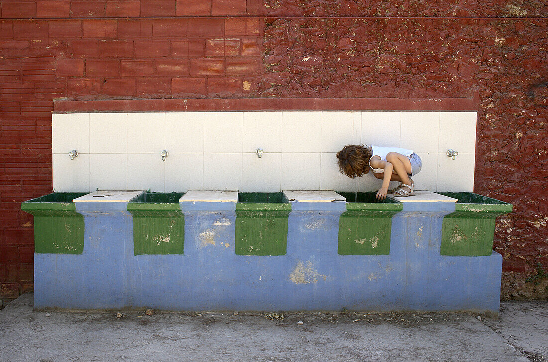5 year old girl drinking at washing place