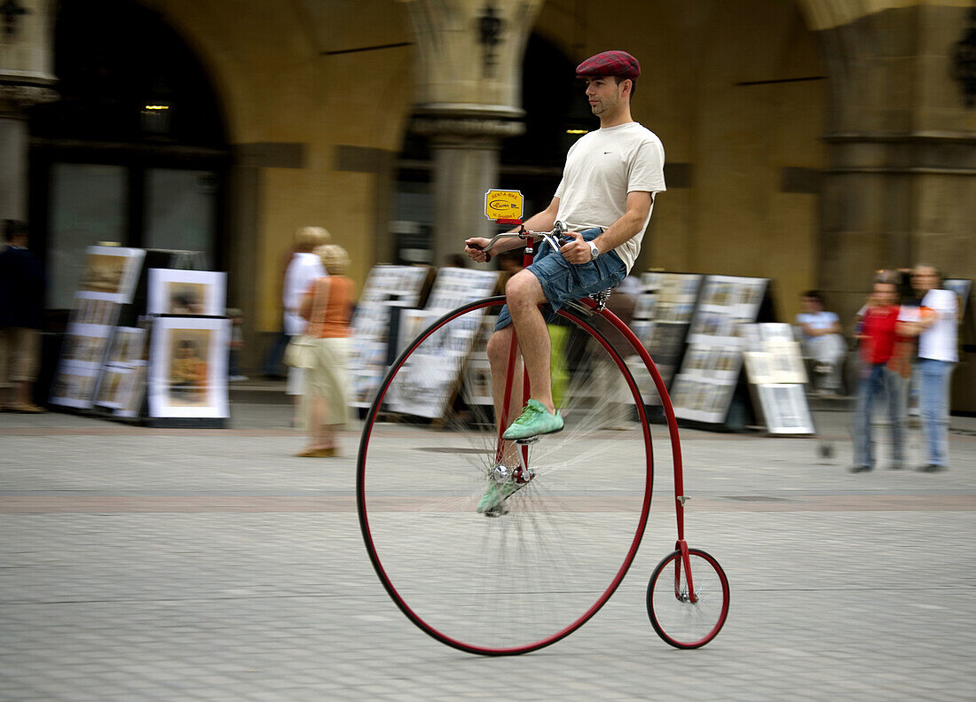 Poland,  Krakow,  Main Market Square,  man rides an old bicycle
