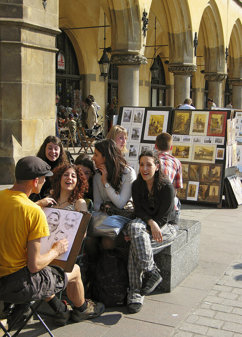 Poland Krakow,  Tourist women poses for drawing,  Main Market Square