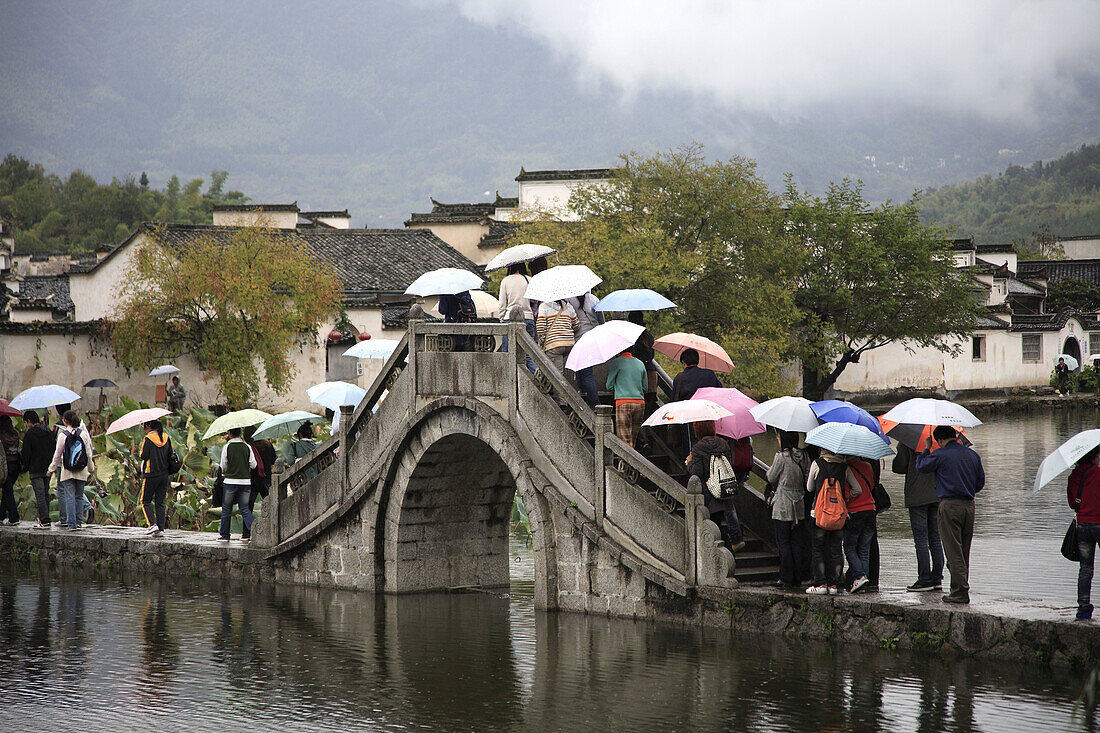 China,  Anhui Province,  Hongcun village,  bridge,  people with umbrellas