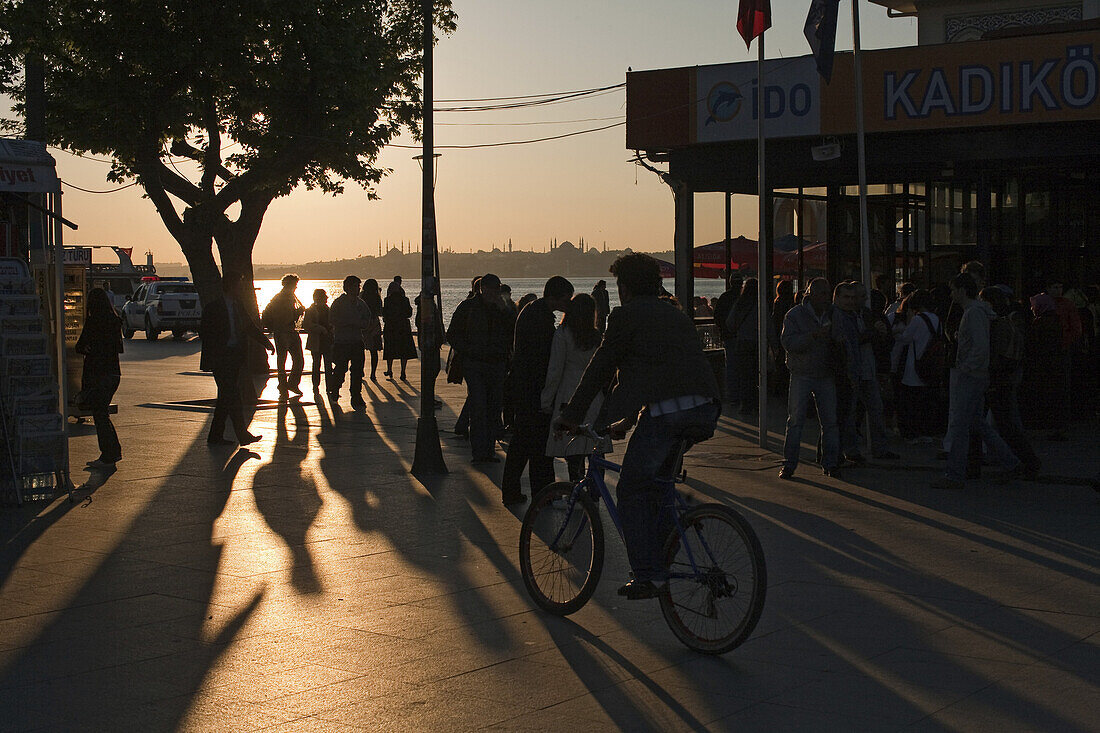 silhouettes against sunset at the harbour front, Istanbul, Turkey