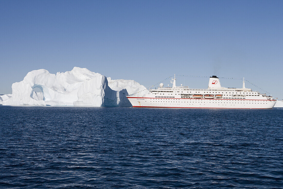 Cruise ship MS Deutschland and iceberg with hole from Ilulissat Kangerlua Icefjord, Ilulissat (Jakobshavn), Disko Bay, Kitaa, Greenland