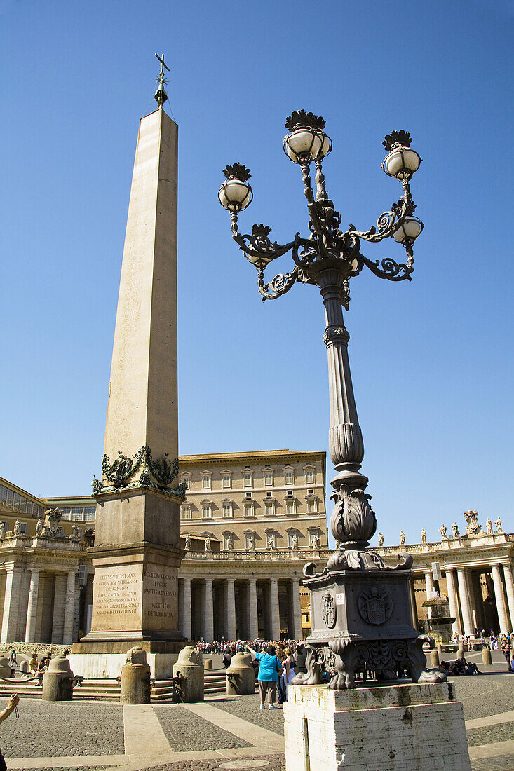 Obelisk,  streetlamp and tourists in Saint Peter’s Square,  Piazza San Pietro,  Vatican City,  Rome,  Italy