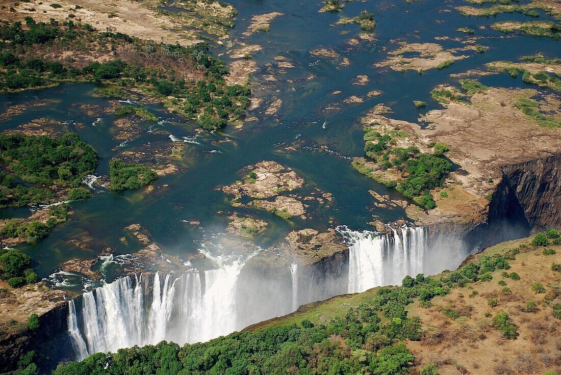 victoria falls from the air,  waterfall of the zambezi river flowing from zambia to zimbabwe