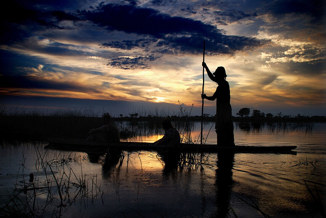 a  trip in a mokkoro canoe at sunset in the okavango delta in botswana with local guide to see sky light up and enjoy nature