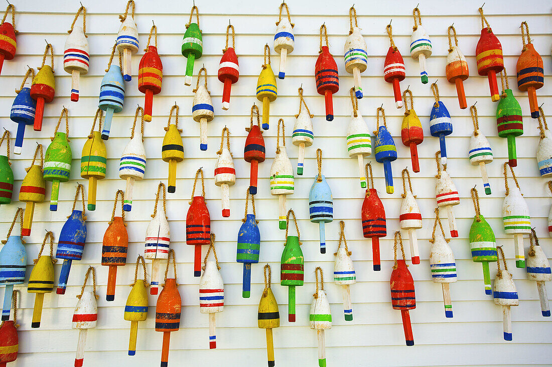 Colorful lobster trap bouy´s hang from a wall in a harbor. Maine,  USA