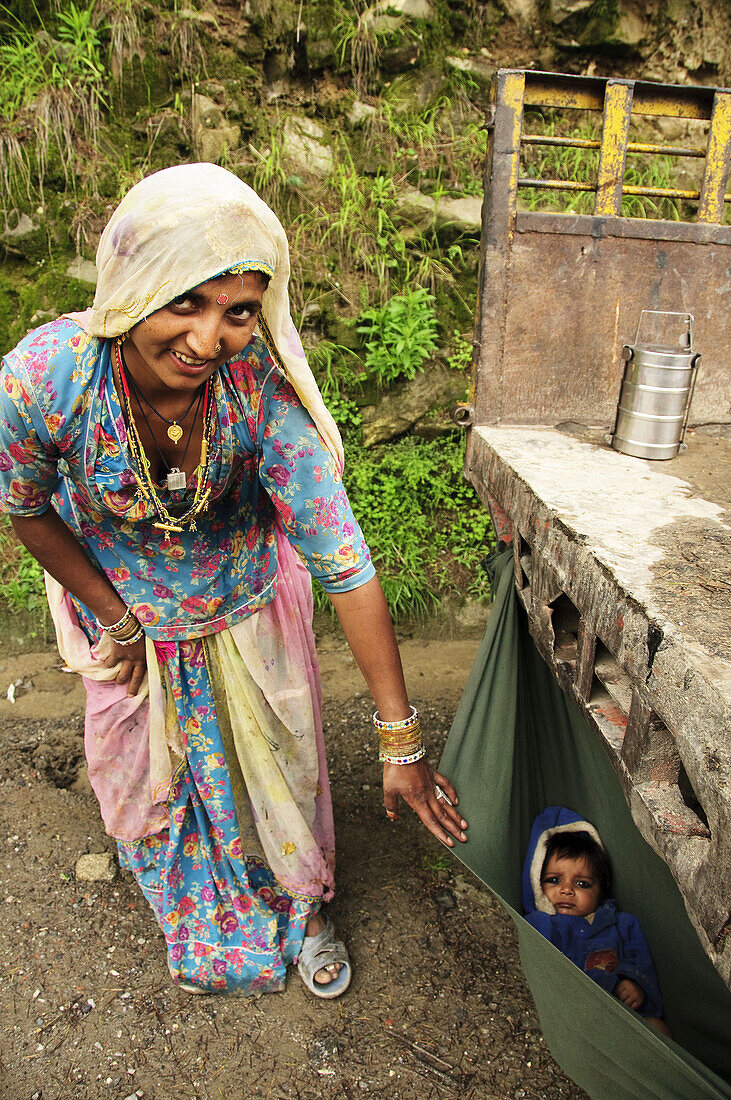 A hindu mother showing her child in a hanging bed on the back of a truck Naggar,  Himachal Pradesh,  India