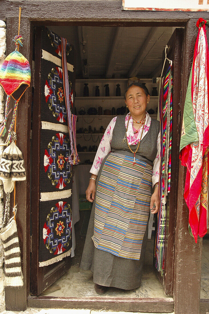 Tibetan woman standing in the doorway of her store  Marpha,  Nepal