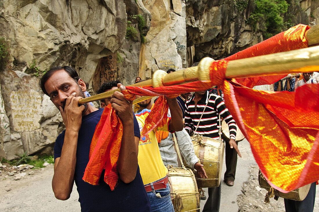 A man blowing a horn in a wedding parade Manikaran,  Kullu Valley,  Himachal Pradesh
