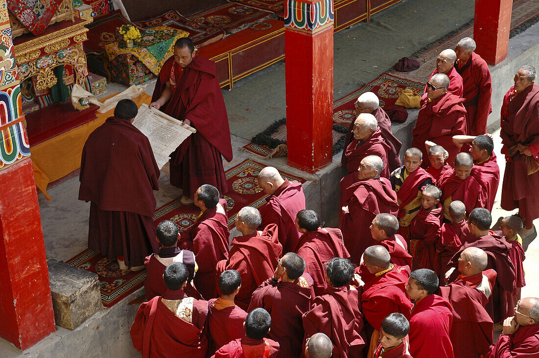 A crowd of Tibetan Buddhist monks watch the unrolling of a holy scroll Lama Yuru,  Ladakh,  India