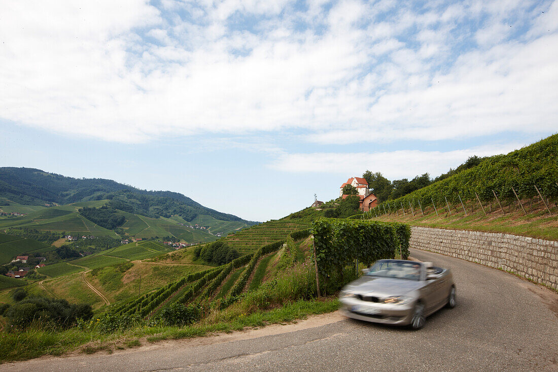 Convertible passing country road, Durbach-Staufenberg, Black Forest, Baden-Wuerttemberg, Germany