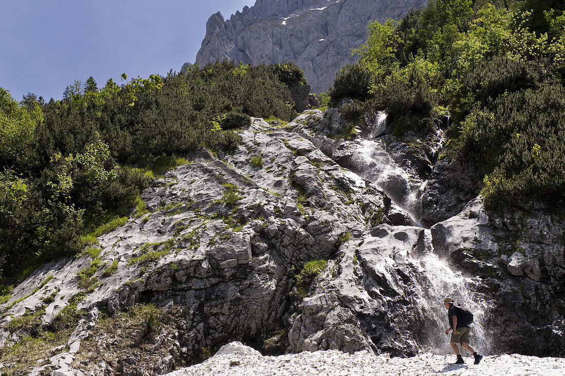 Hiker near waterfall, Kaiser range, Kaisertal, Ebbs, Tyrol, Austria