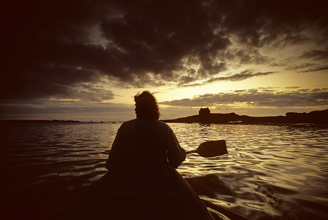 Angler im Ruderboot vor der Küste bei Sonnenuntergang, Bretagne, Frankreich, Europa