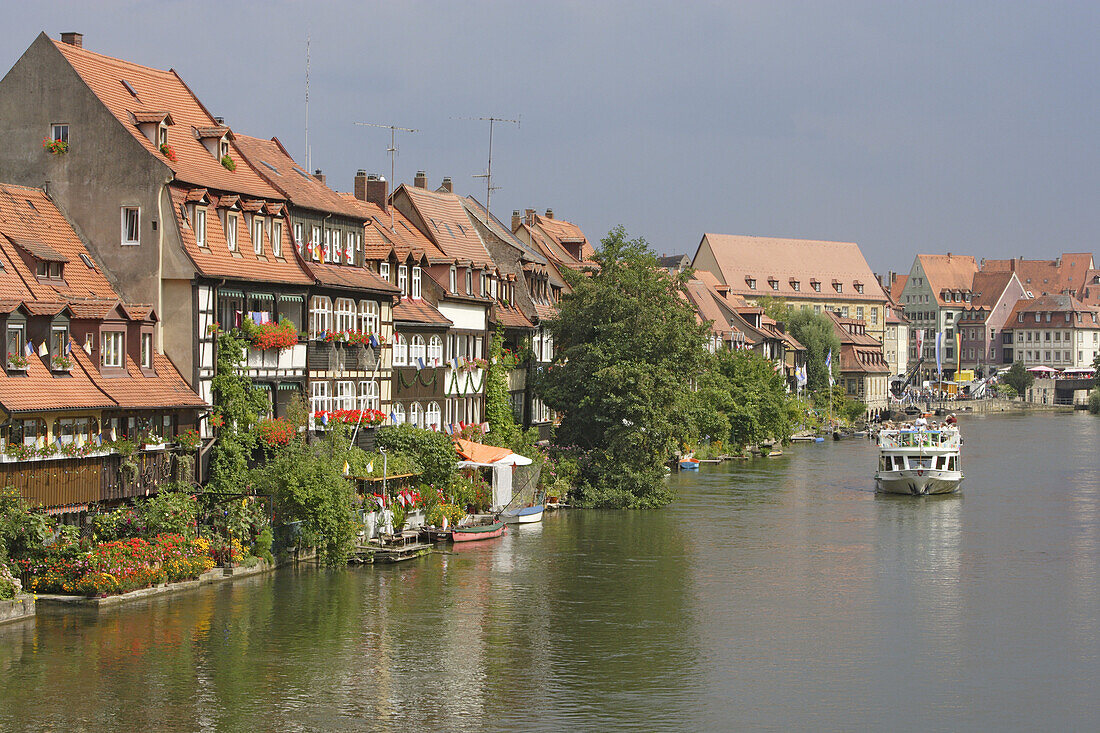 Cruise boat on the river Regnitz in the houses of little Venice, Bamberg, Upper Franconia, Bavaria, Germany