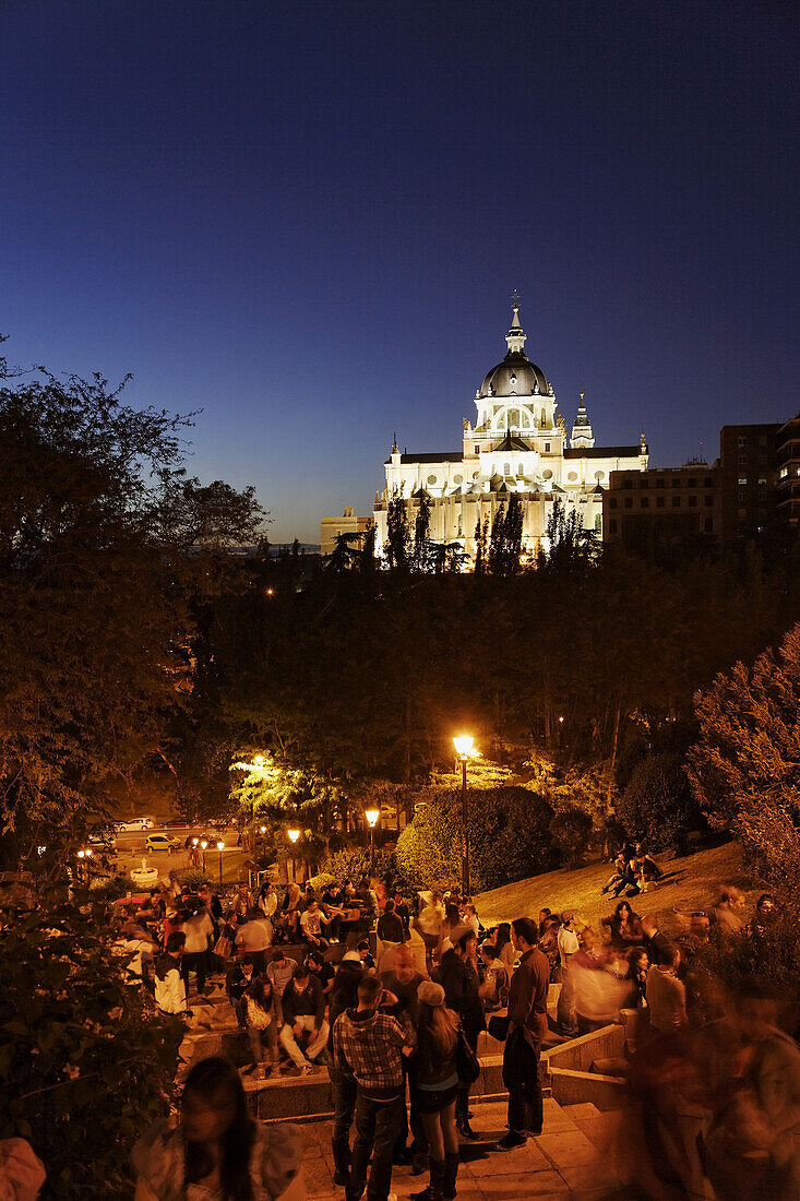 Catedral de Nuestra Senora de la Almudena at night, guests in a bar in foreground, Madrid, Spain