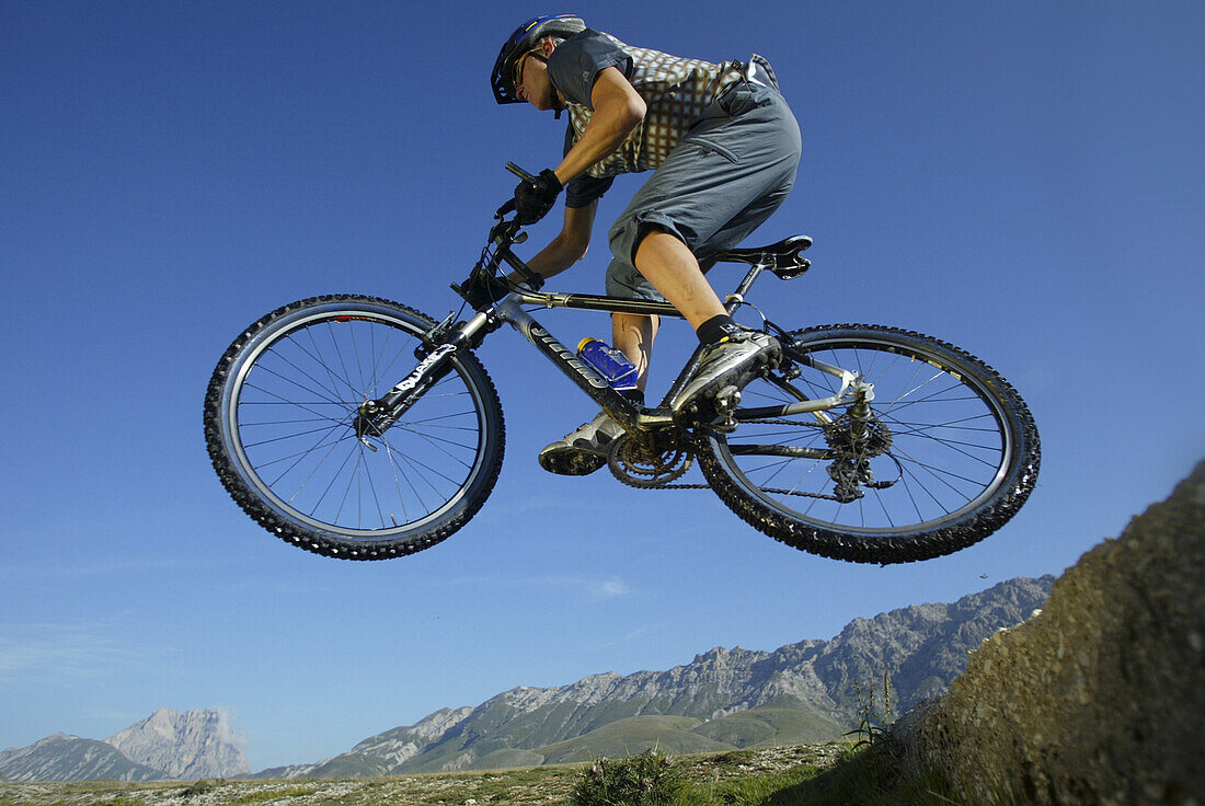 Mountainbiker in mid air, Gran Sasso d'Italia, Abruzzo, Italy