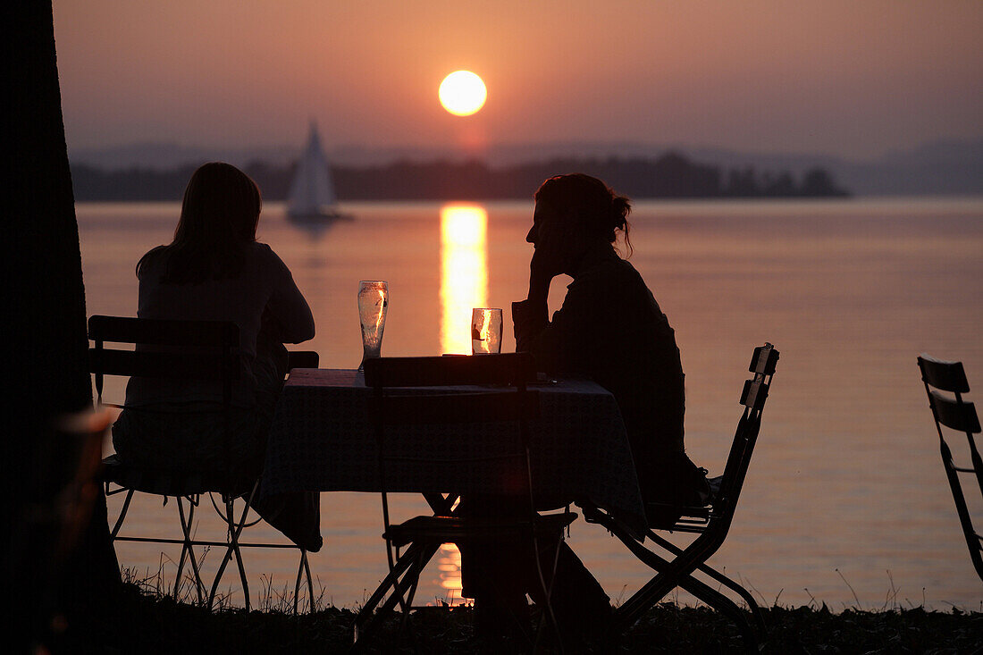 Two people in sunset, Feldwies, Lake Chiemsee, Chiemgau, Bavaria, Germany
