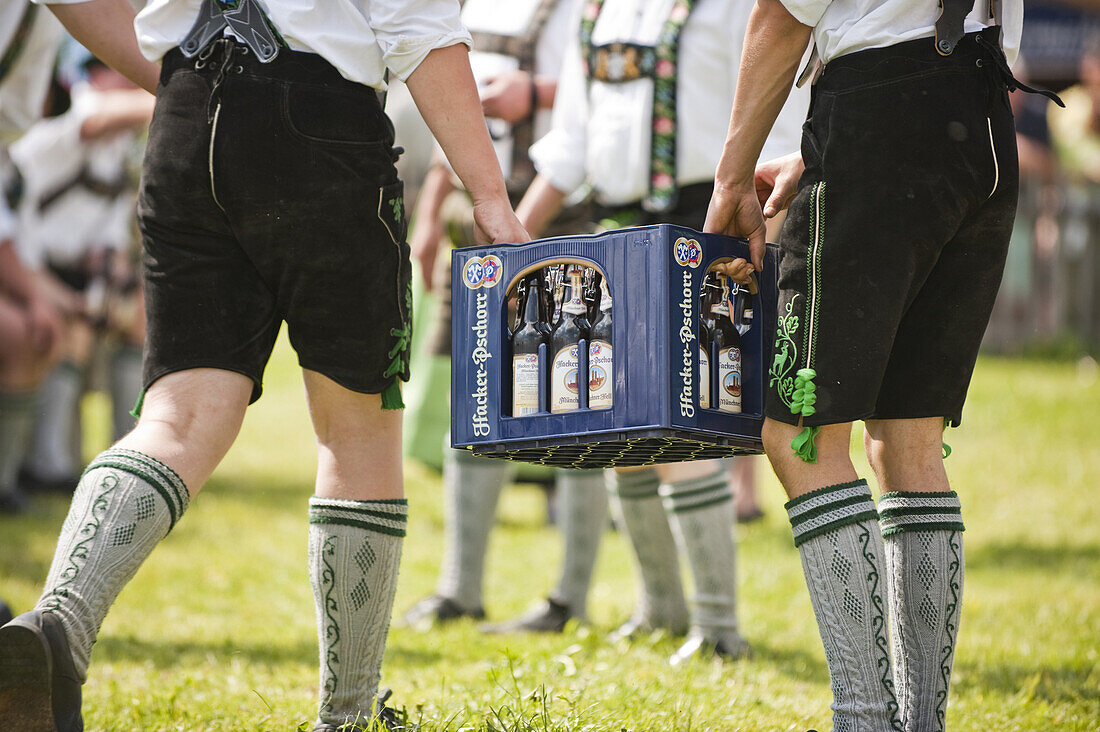 Zwei Männer in Lederhosen tragen Bierkiste, Mailaufen, Antdorf, Oberbayern, Deutschland