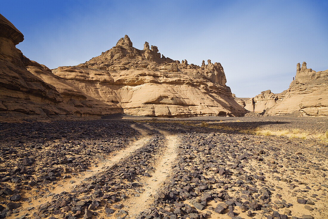 Car track in stony desert, Akakus mountains, Libya, Sahara, North Africa
