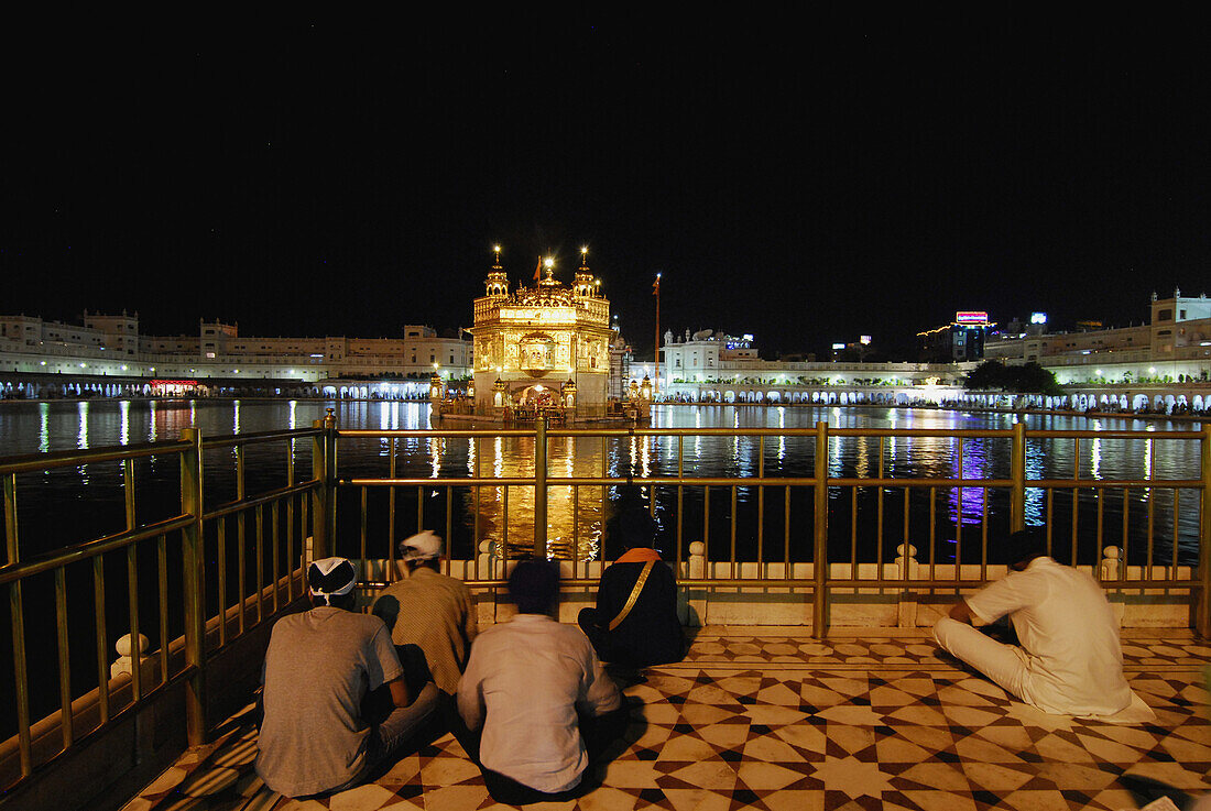 Goldener Tempel bei Nacht und betende Sikhs, Heiligtum der Sikhs, Amritsar, Punjab, Indien, Asien