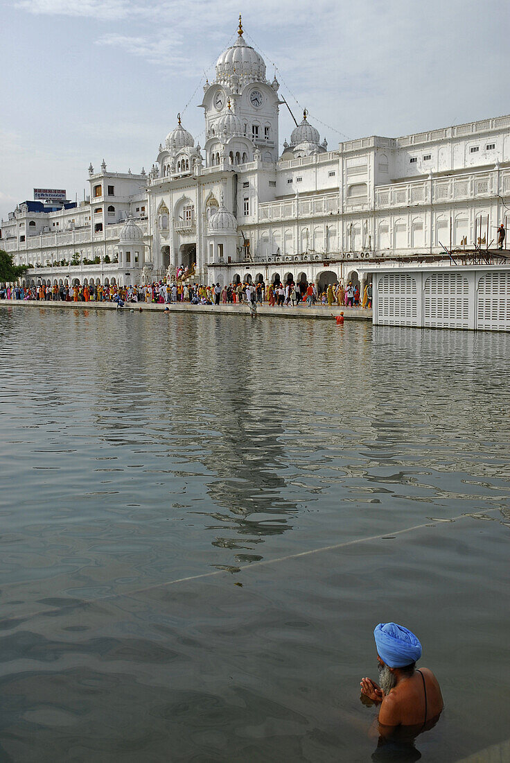 Man with turban bathing in water basin in front of the Golden Temple, view at main entrance, Sikh holy place, Amritsar, Punjab, India, Asia
