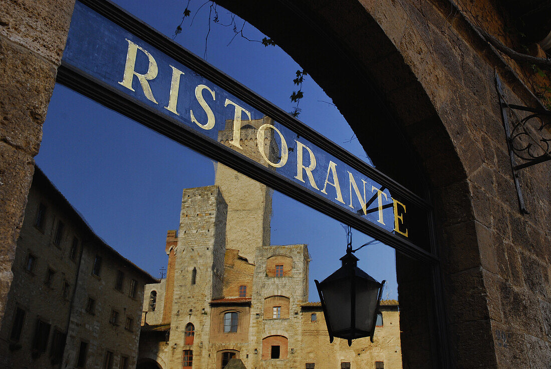 Reflection of old town with genera towers in a restaurant's window, San Gimignano, Tuscany, Italy, Europe