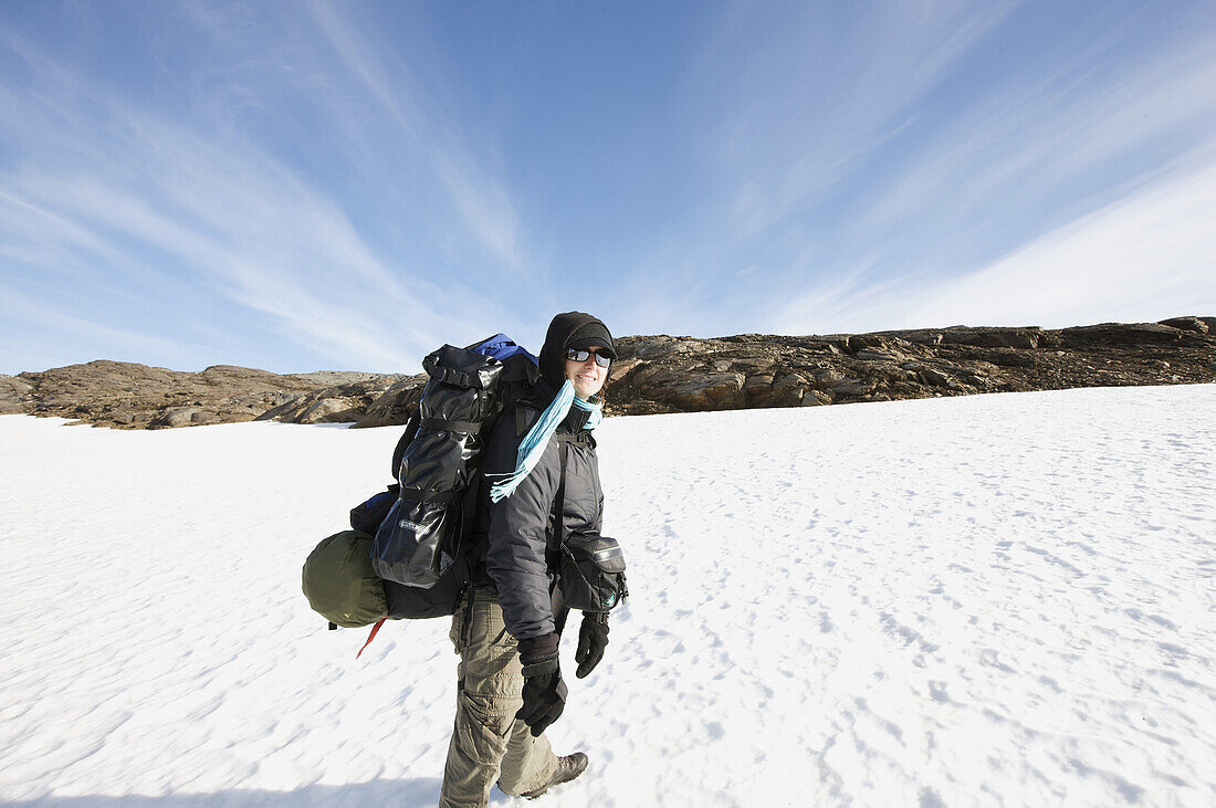 Wanderin mit Rucksack überquert Schneefeld, Saltfjell, Norwegen, Skandinavien, Europa