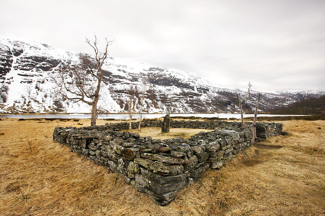 Old gravesite in front of snow covered mountains, Aurlandsdalen, Aurland, Sogn og Fjordane, Norway, Scandinavia, Europe
