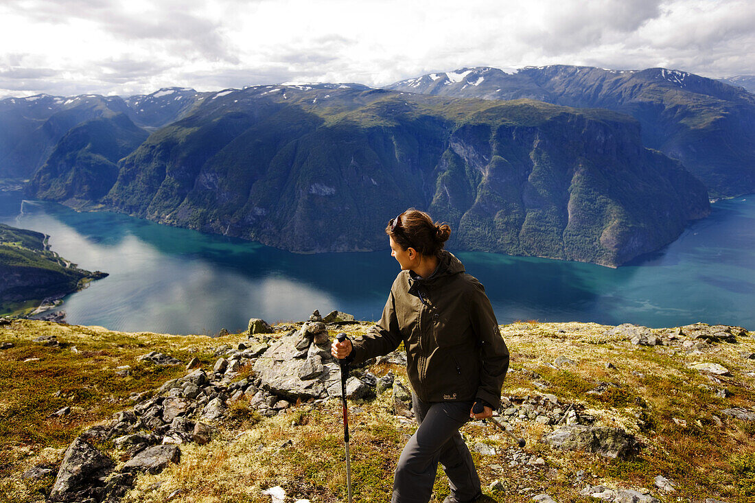 Junge Frau wandert mit Blick auf den Aurlandsfjord, Prest, Aurland, Sogn og Fjordane, Norwegen, Skandinavien, Europa