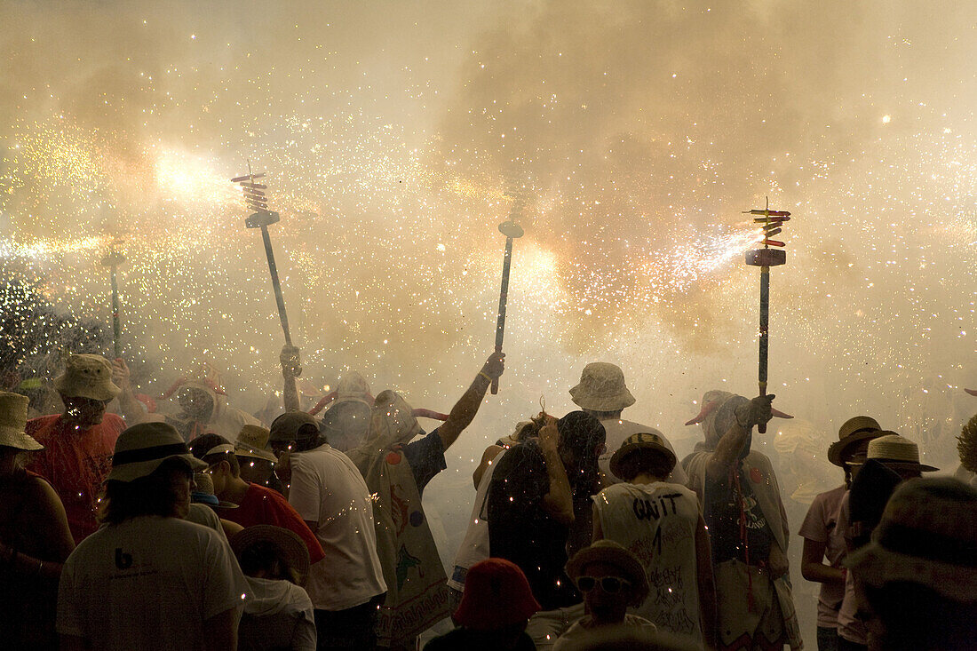 Menschen mit Feuerwerkskörpern beim Festival der heiligen Thekla, Sitges, Katalonien, Spanien, Europa