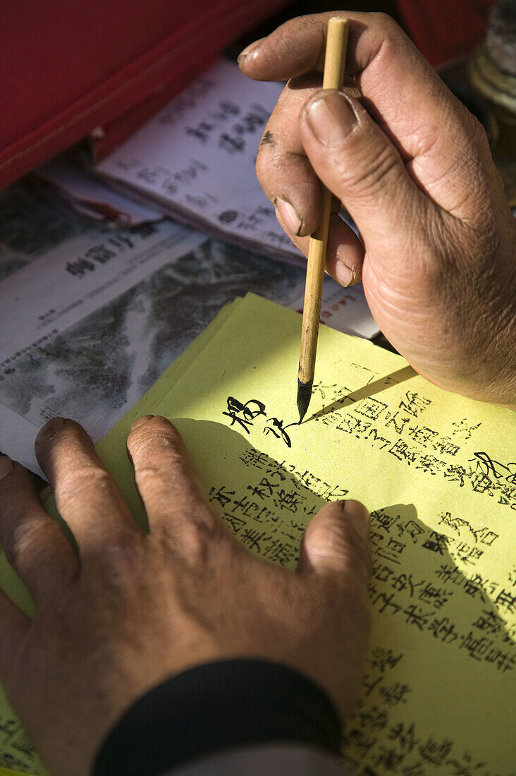 China. Yunnan Province. Erhai Hu Lake Area. Xizhou: Xizhou town market. Chinese calligrapher