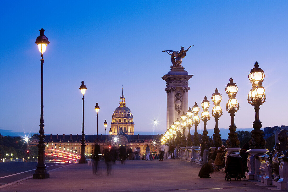 Pont Alexandre III bridge towards Hotel des Invalides and Eglise du Dome at dusk, Paris, France