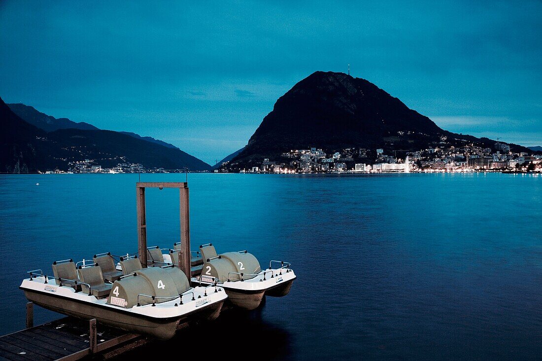 Switzerland, Ticino, Lake Lugano, Lugano, Monte San Salvador and paddleboats, evening