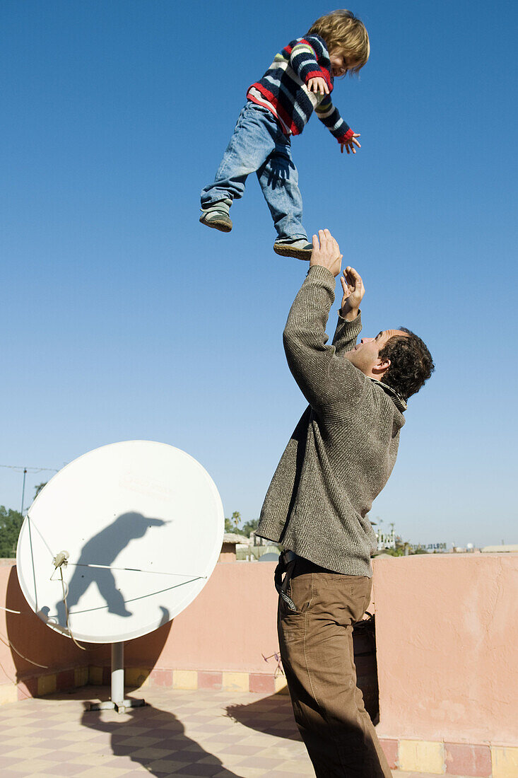 Adult, Adults, Amusement, Arms raised, Bond, Bonding, Bonds, boy, boys, child, children, Color, Colour, Contemporary, dad, Daytime, exterior, families, family, father, fathers, Flat roof, Flat roofs, Flight, Flights, Fly, Flying, Fun, happiness, happy, hu