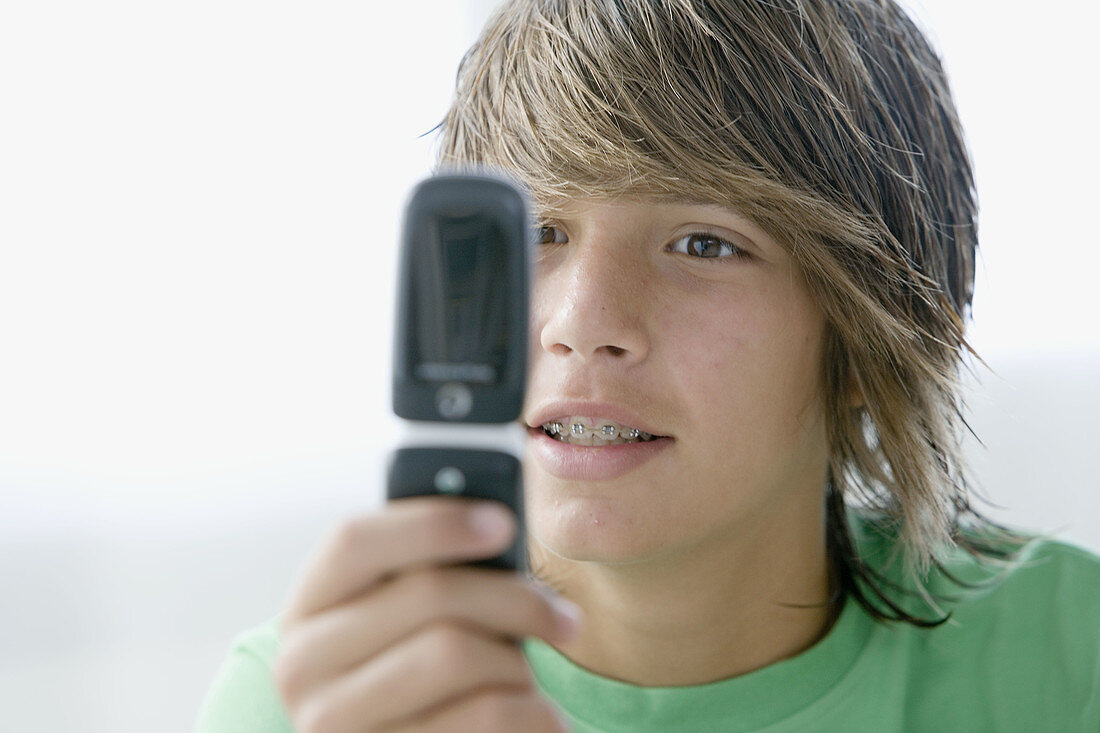 Blond, Blonds, Boy, Boys, Brace, Braces, Caucasian, Caucasians, Cell phone, Cell phones, Cellular phone, Cellular phones, Close-up, Closeup, Color, Colour, Communication, Communications, Contemporary, face, faces, Fair-haired, hand, hands, headshot, heads