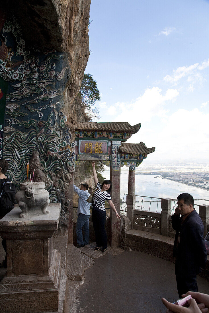 Chinesische Touristen vor dem Drachentor, Balken des Tores zu berühren bringt Glück, Blick über den Dian See, Hügel des Schlafenden Buddhas, Taihua Tempel, Kunming, Yunnan, Volksrepublik China, Asien