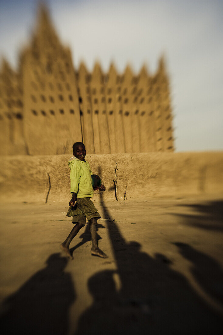 Lachender Junge vor der Moschee von Djenna, Mali, Afrika