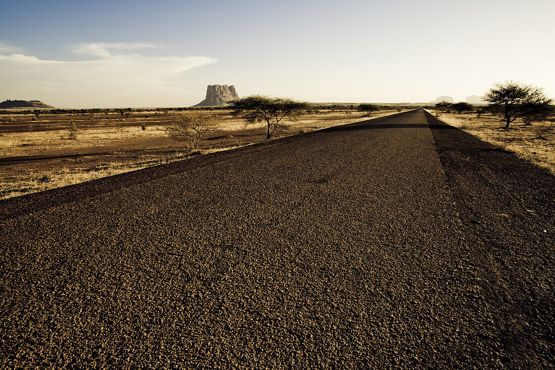 Empty country road under clouded sky, Mali, Africa