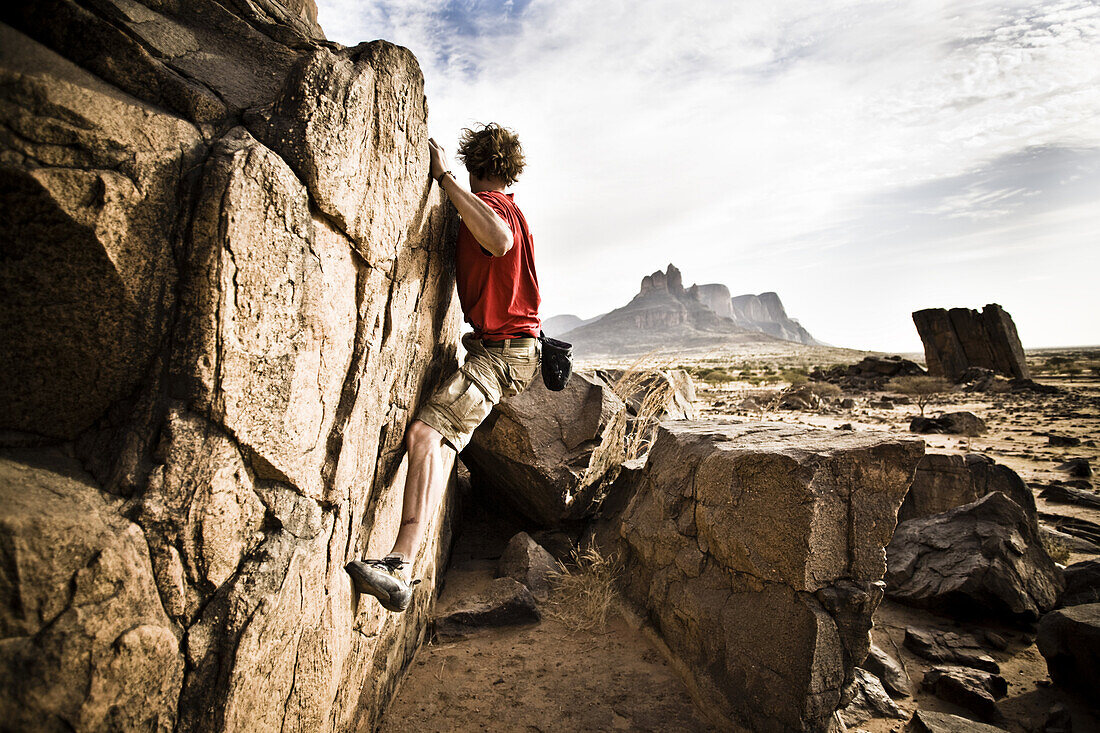 Young man bouldering on a rock, Hand of Fatima, Hombori, Mali, Africa