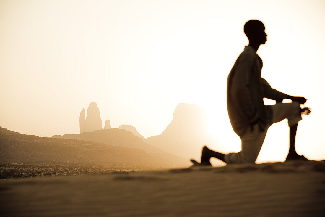 Kniender Junge vor Felsformation bei Sonnenuntergang, Hombori, Mali, Afrika
