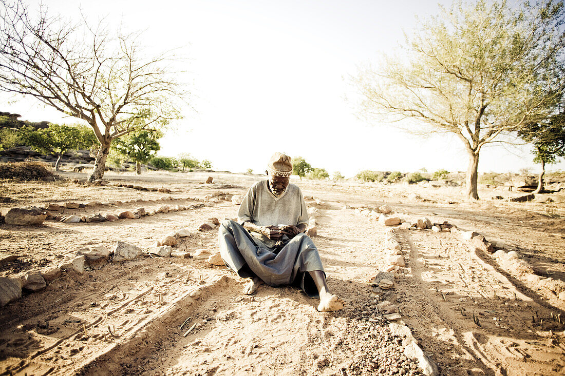 Afrikaner sitzt auf dem Boden, Wahrsager der Dogons, Sangha, Falaise de Bandiagara, Mali, Afrika