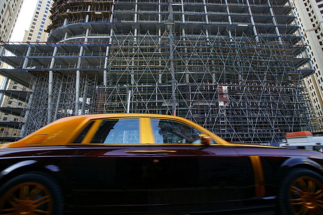 Car in front of high rise building with scaffolding, Jumeirah Beach Residence, Dubai, UAE, United Arab Emirates, Middle East, Asia