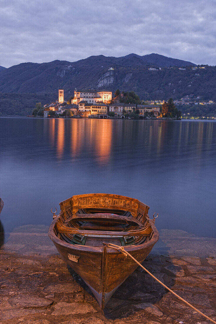 Rowing boats on the lake shore of Lake Orta, Isola San Giulio in the background, Orta San Giulio, Piedmont, Italy