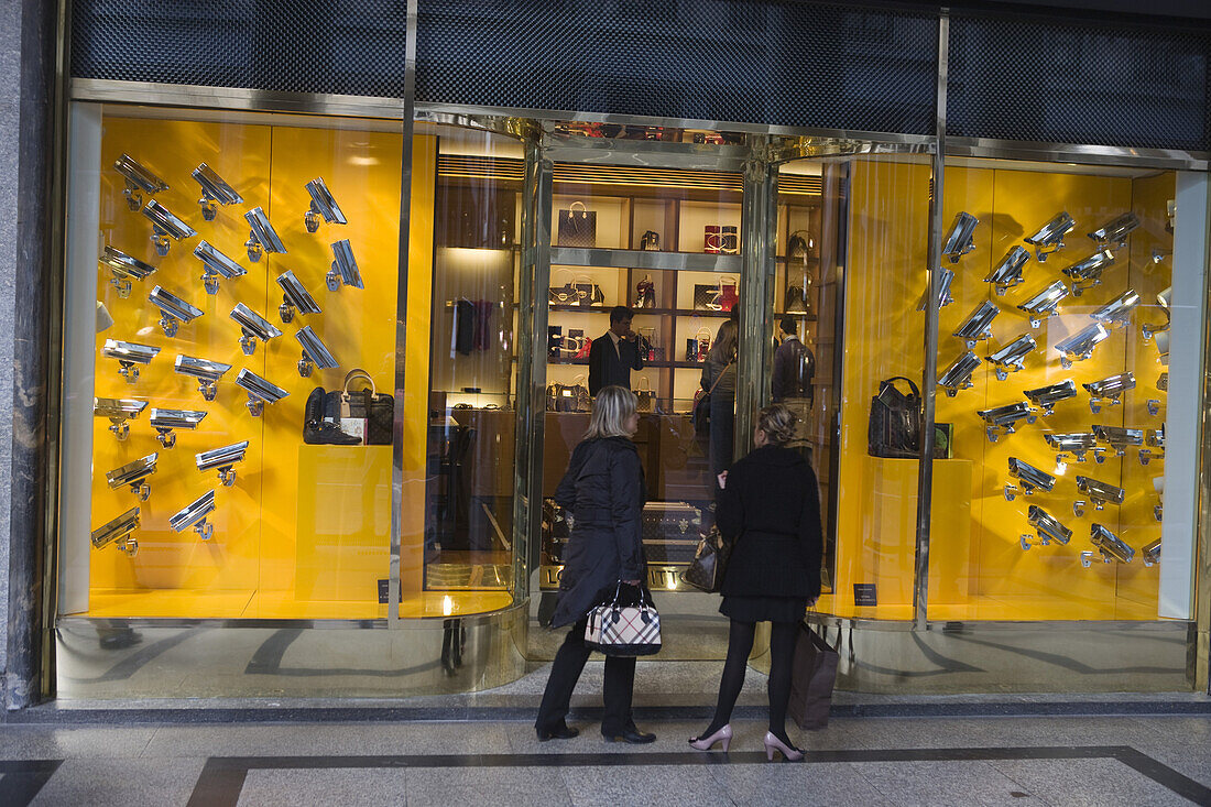 Two women looking at the window display of a Louis Vuitton shop, Via Roma, Turin, Piedmont, Italy