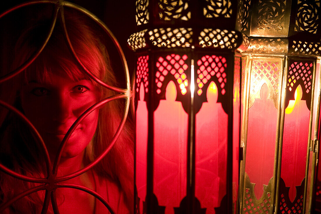 Woman poses in front of a Moroccan lamps at Café Arabe restaurant, Marrakech, Morocco