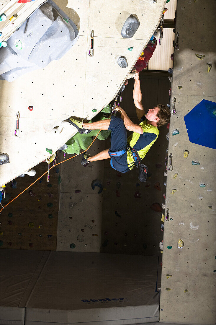Man climbing on a overhang inside a climbing gym, Linz, Upper Austria, Austria