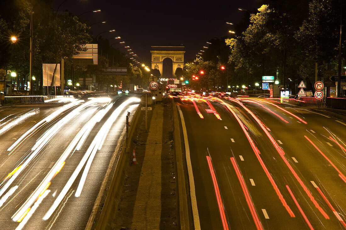 Belebte Strasse zum Arc de Triomphe bei Nacht, Paris, Frankreich