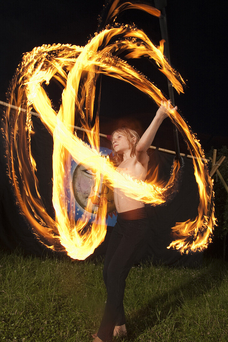 Junge jongliert mit Feuer bei Nacht, Österreich