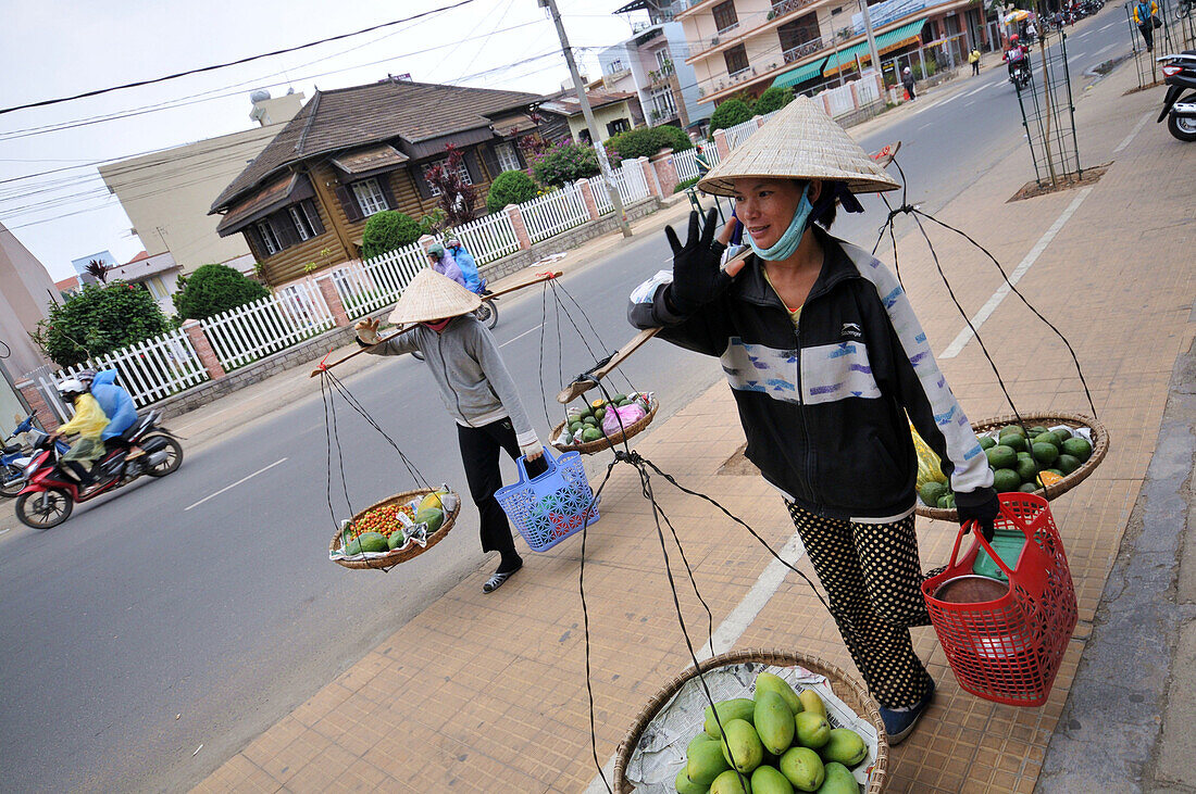 Two women carrying fruit and vegetables, Da Lat in the southern mountains, Vietnam
